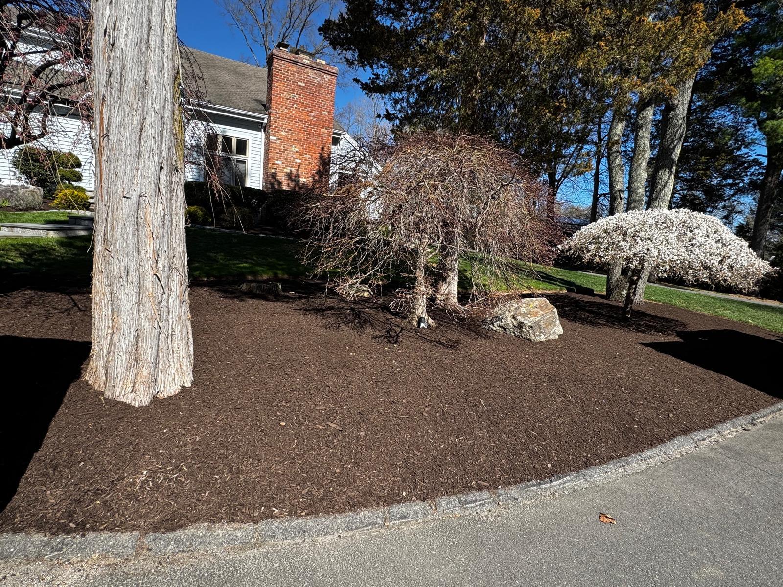 Hillside re-mulched and stabilized with a stone block retaining wall